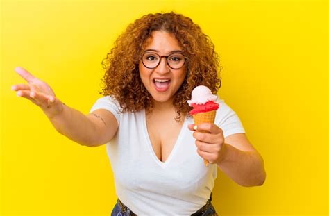 Joven Latina Sosteniendo Un Helado Aislado Sobre Fondo Amarillo Recibiendo Una Agradable