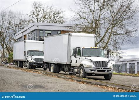 Middle Duty Rigs Day Cab Semi Trucks With Box Trailers Standing On The City Street Waiting For