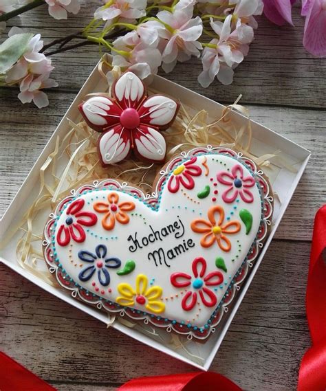 A Decorated Heart Shaped Cookie Sitting On Top Of A White Box Next To