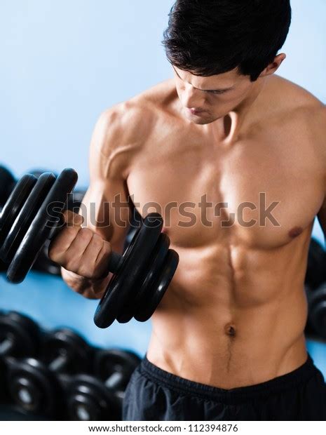 Handsome Muscular Man With Nude Body Uses His Dumbbell To Exercise