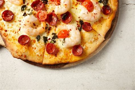 Image Of Gourmet Wood Fired Prawn And Sausage Pizza On Table Austockphoto