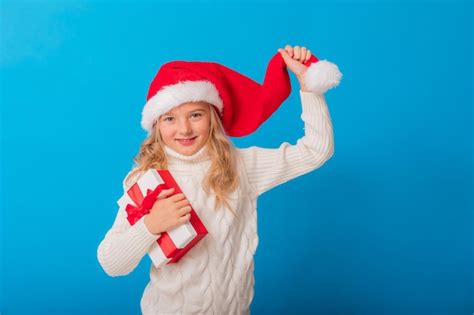 Una Linda Ni A Con Un Gorro De Pap Noel Tiene Un Regalo En Un Fondo