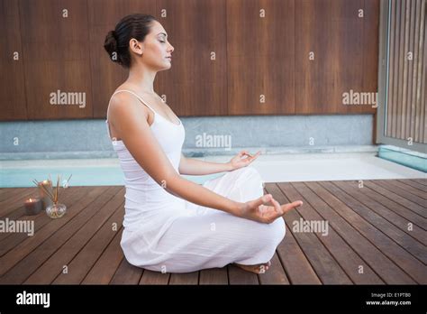 Peaceful Brunette In White Sitting In Lotus Pose Stock Photo Alamy