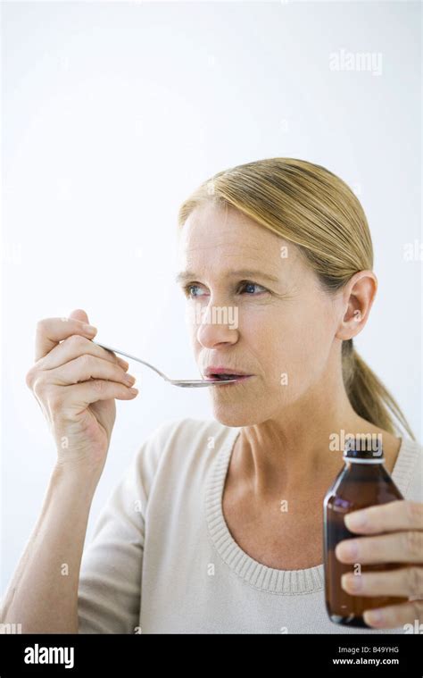 Mature Woman Taking A Spoonful Of Medicine Stock Photo Alamy