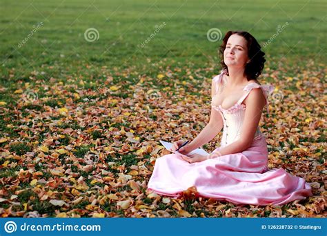 Fine Emotional Brunette Writing On Paper Sitting On Autumn Leaves And