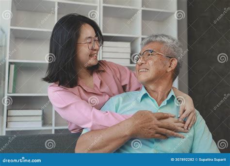 A Father And Daughter Sat In The Living Room Happily Spending Time