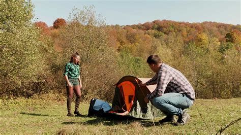 Tourist and his girlfriend setting up the camping tent in forest near the mountains. 38185493 ...