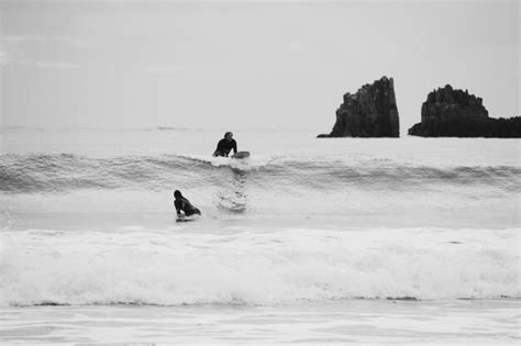 Premium Photo Surfers On Beach Against Sky