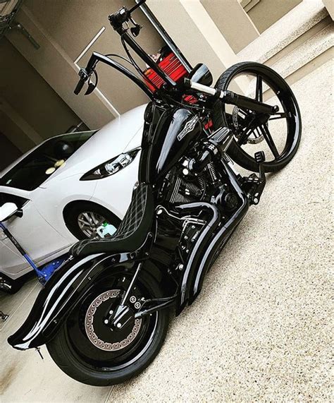 A Motorcycle Parked Next To A White Car