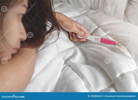 Unhappy Young Asian Woman Holding Pregnancy Test Showing A Negative