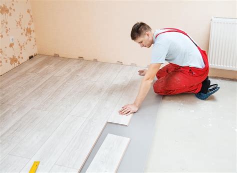 Premium Photo Man Putting Hardwood Floor Panels In Home