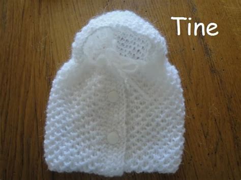 A White Knitted Hat Sitting On Top Of A Wooden Floor