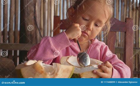 Little Cute Girl Eating Coconut By Spoon At Cafe Stock Image Image Of