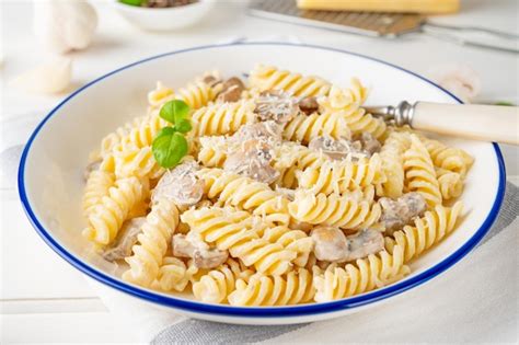 Premium Photo Fusilli Pasta With Mushrooms Cheese And Fresh Basil In