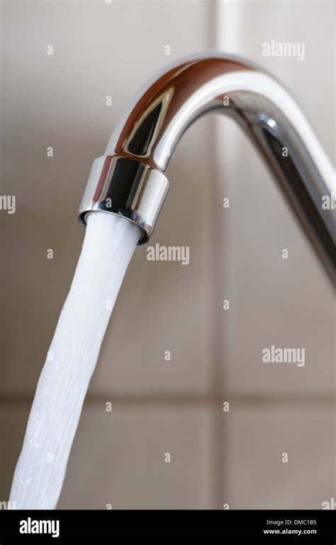 Vertical Image Of A Tap With Water Flowing Strongly Under High Pressure