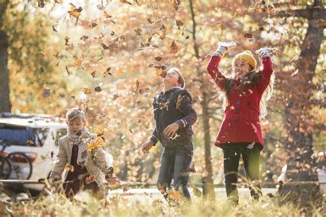 Jungen und Mädchen Herbstblätter über den Kopf werfen