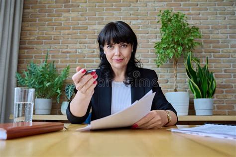 Talking Mature Businesswoman With Documents Looking In Webcam Stock Photo Image Of Indoors