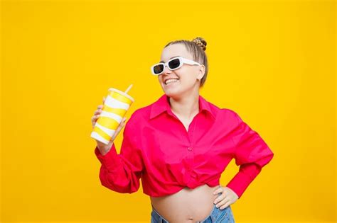 Premium Photo Cheerful Pregnant Woman In Pink Shirt Holding Tasty