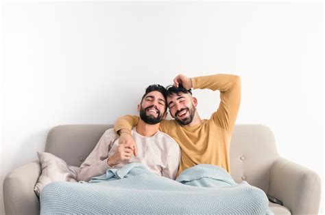 Homosexual Young Gay Couple Enjoying Together On Sofa Against White Wall Free Photo