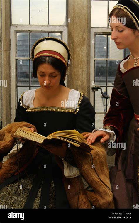 2 Beautiful Women In Tudor Dress Sit By A Window Chatting And Reading