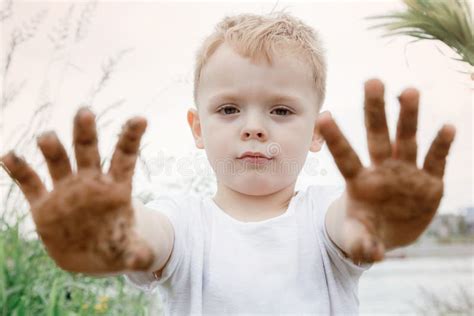 Un Niño Muestra Sus Sucias Manos Después De Jugar Con La Arena En