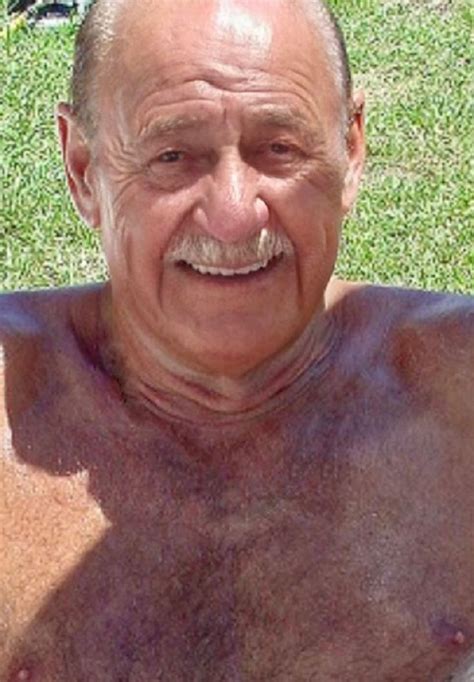 An Older Man With No Shirt Sitting In The Grass