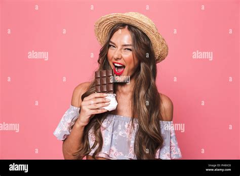 Portrait Of A Cheerful Young Girl In Summer Clothes Biting Chocolate