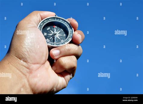 hand holding  navigation compass blue sky background stock photo alamy