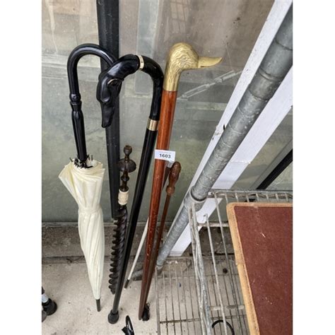 An Assortment Of Walking Sticks And Umbrellas To Include One With A