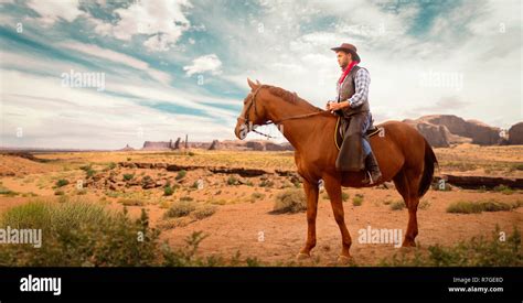 Cowboy In Leather Clothes Riding A Horse In Desert Valley Western