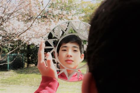 Premium Photo Close Up Of Boy Looking In Mirror At Park