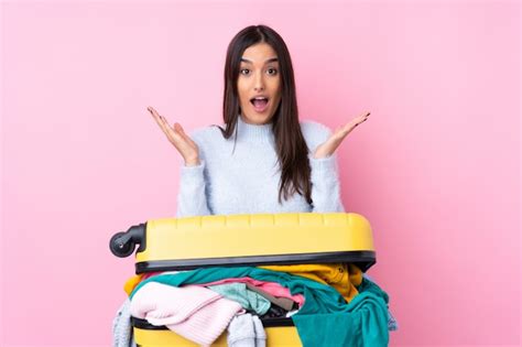 Mujer Viajera Con Una Maleta Llena De Ropa Sobre Pared Rosa Aislada Con