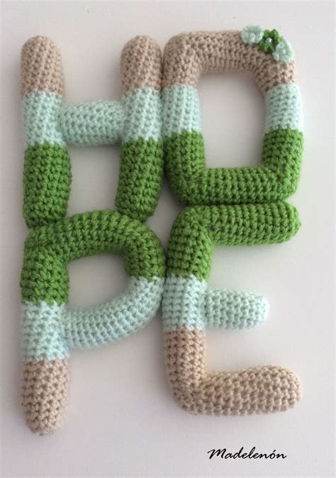 Crocheted Letters Made To Look Like Green And White Yarns Are Arranged