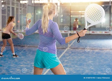 Sporty Woman Padel Player Hitting Ball With A Racket On Hard Court