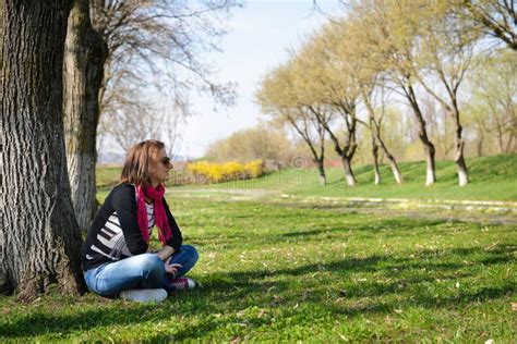 Thoughtful Brunette Sitting Under A Tree In Park On A Sunny Da Stock Photo Image Of