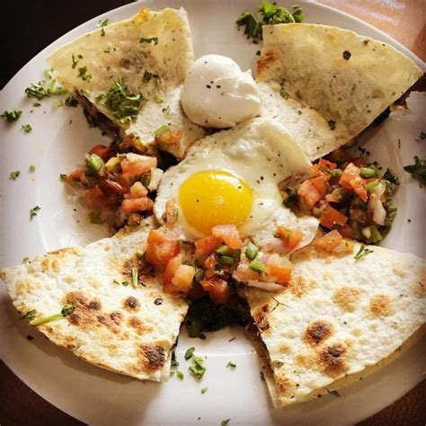 An Egg Is Sitting On Top Of Some Tortilla Chips With Other Toppings