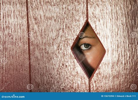 Mujer Que Mira a Través De Un Agujero En La Pared Foto de archivo