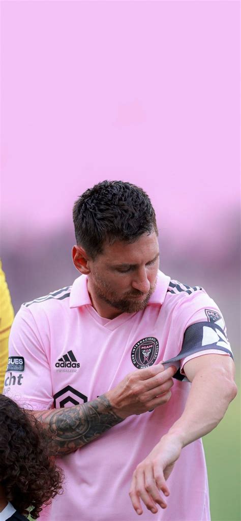 A Man With Tattoos On His Arm Is Standing Next To A Woman In A Pink Shirt