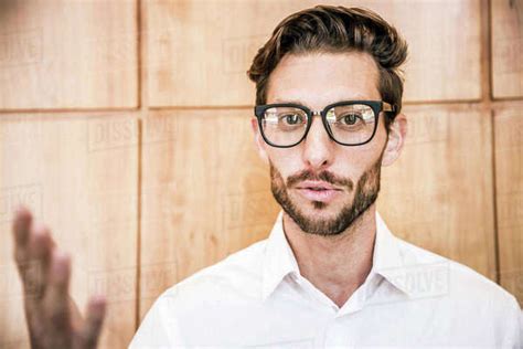 Young Man Wearing Glasses Looking At Camera Smiling Gesticulating