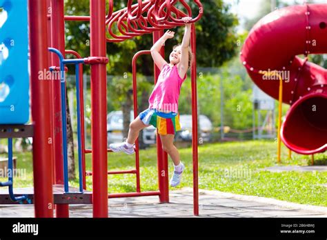 Child On Monkey Bars Kid At School Playground Little Girl Hanging On