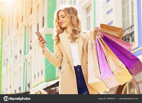 Stylish Beautiful Blonde Hair Smiling Girl With Shoppings Using Her Phone Happy Shopping