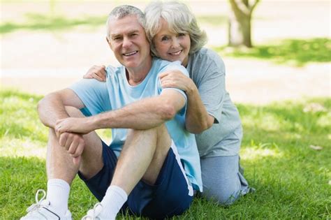 Premium Photo Smiling Mature Couple Sitting On Grass At Park