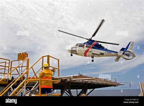 Helicopter landing on offshore marine production oil rig with crew ...