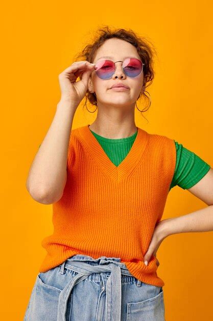 Premium Photo Young Woman Wearing Sunglasses While Standing Against Yellow Background