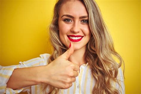 Belle jeune femme portant une chemise à rayures debout sur fond isolé