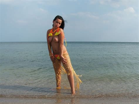 Naked Girl On The Beach Cools Down In The Ocean Photos