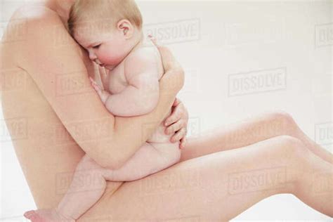 Naked Mother Comforting Naked Baby Resting Against Her Chest Stock