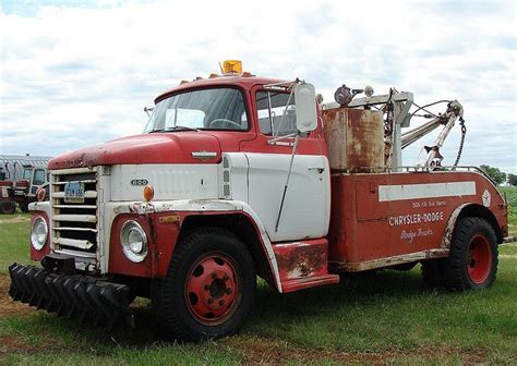 An Old Red And White Fire Truck Parked In A Field With Other Trucks