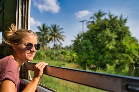 Blonde Meisje Met Haar Haar Haar Omhoog En Zomerkleren In Een Trein Die Uit Het Raam Kijkt Stock