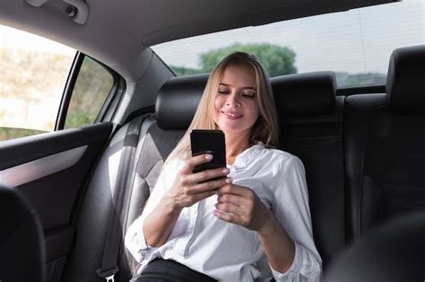 Free Photo Woman Texting On The Back Seat Of The Car